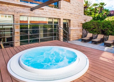 Jacuzzi deck at Spa Viva Blue & Spa, Illes Balears, ES, surrounded by sun loungers and greenery.