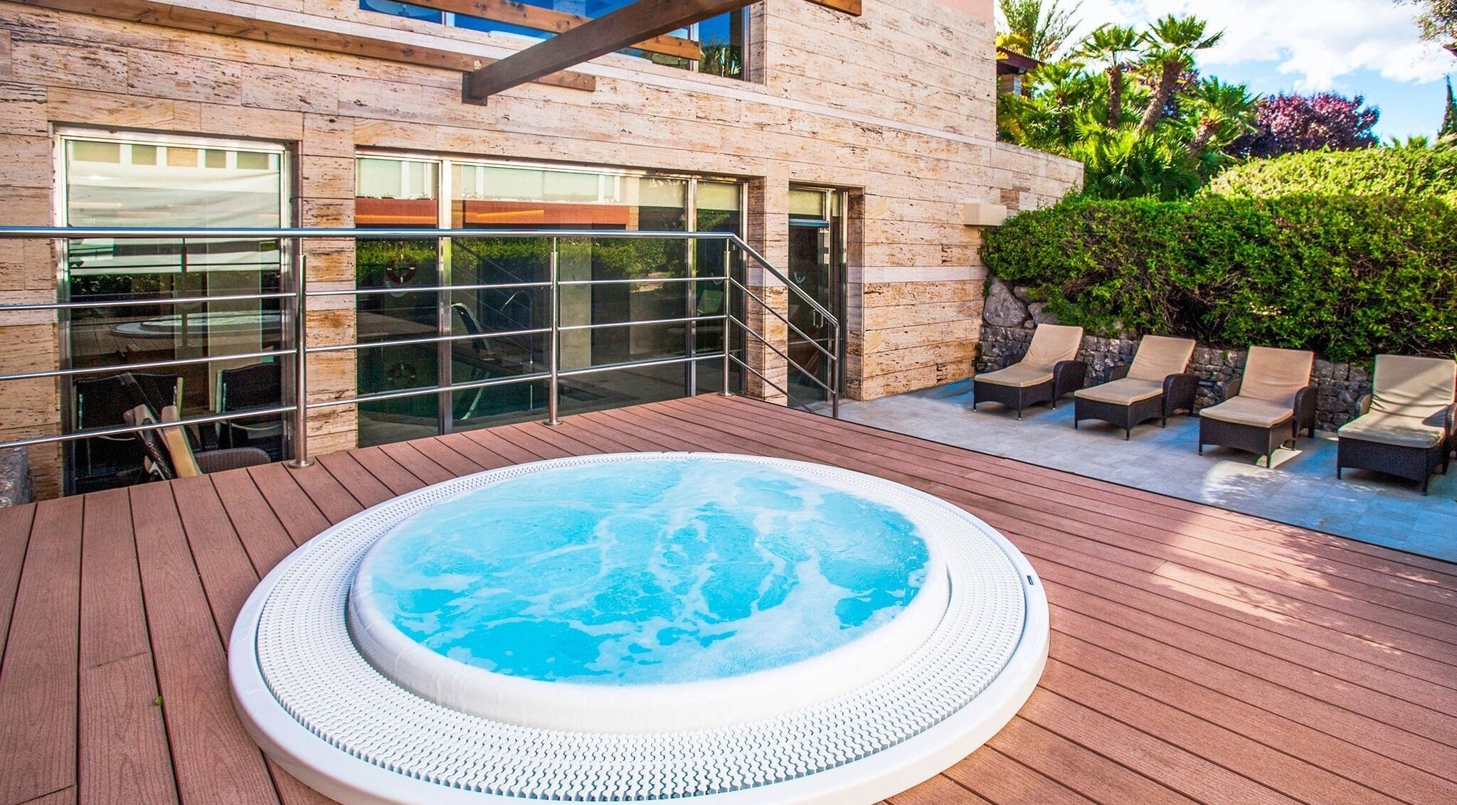 Jacuzzi deck at Spa Viva Blue & Spa, Illes Balears, ES, surrounded by sun loungers and greenery.