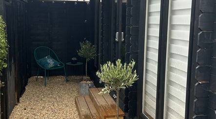 Serene outdoor area at PediHealth + The Foot Clinic in Lancing, England, GB with chair and plants.