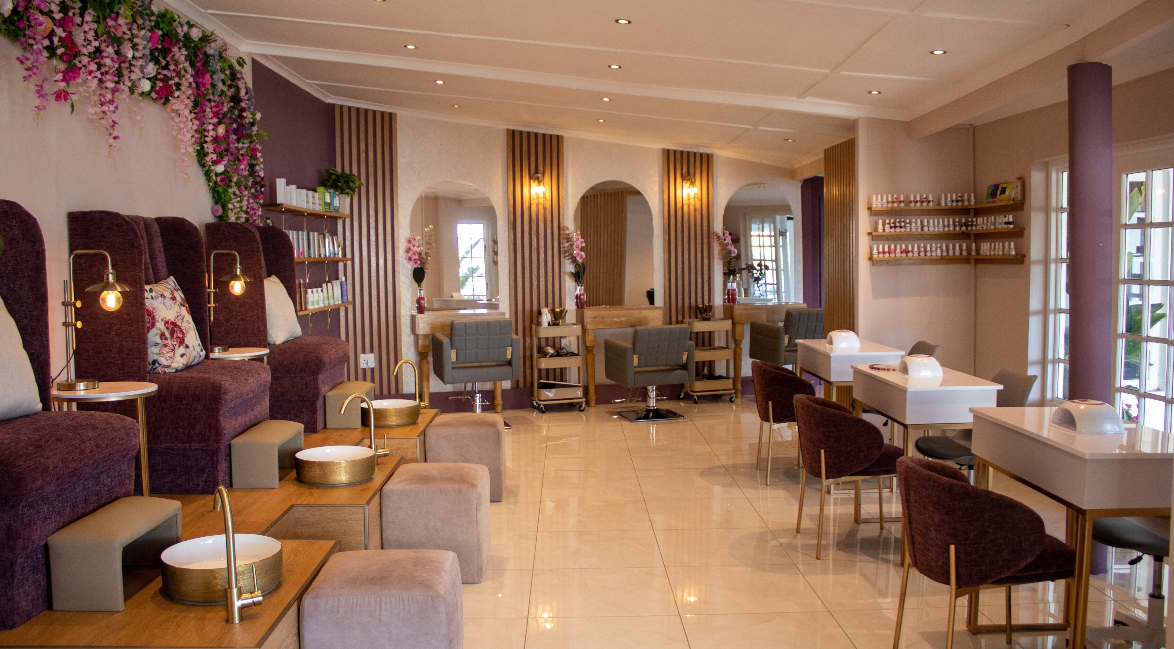 Luxurious interior of Kallos House of Beauty in Cape Town, Western Cape, ZA with plush chairs and nail stations.