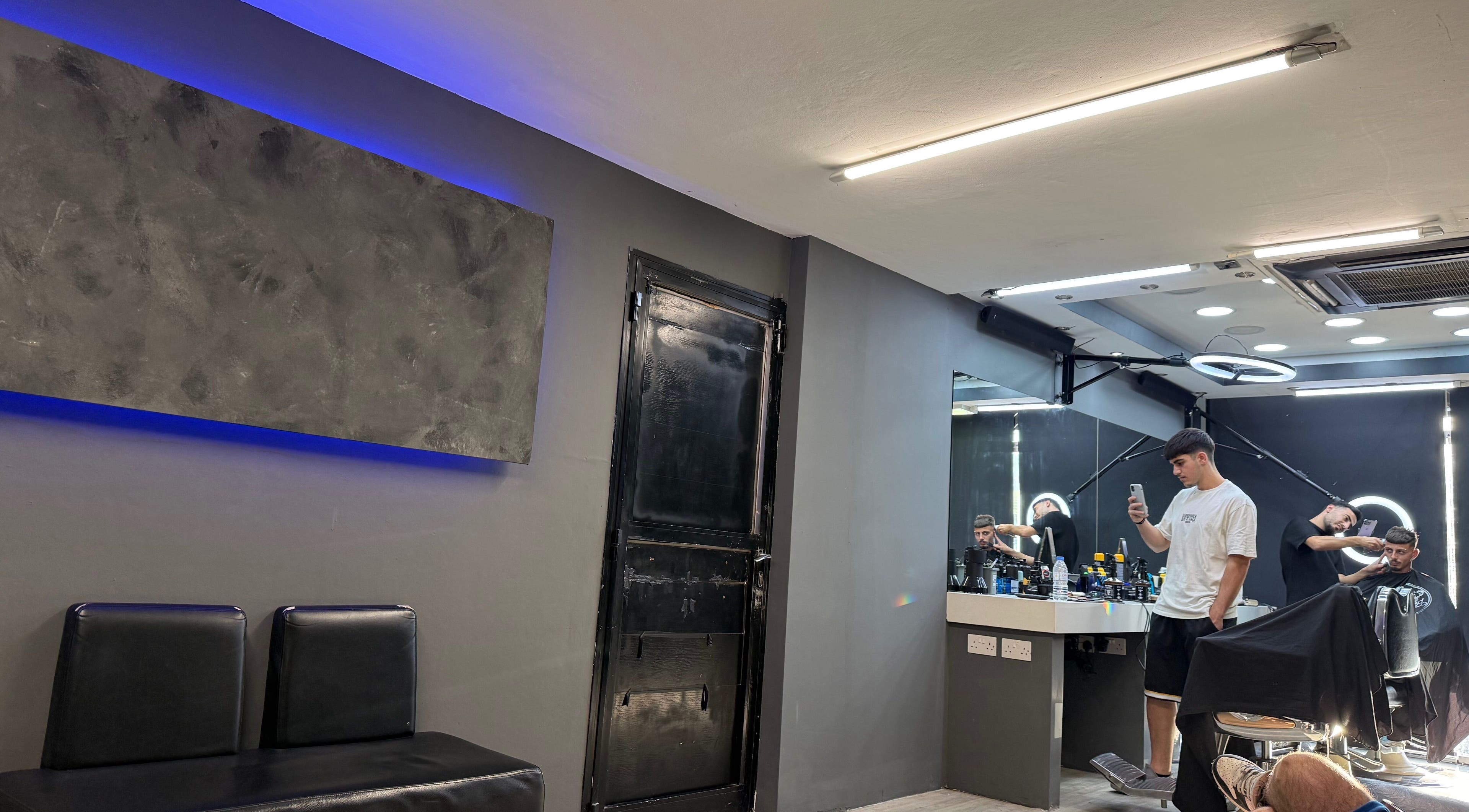 Εσωτερικό του Aggelos Barber Shop στη Λεμεσό, Λεμεσός, CY με μοντέρνα διακόσμηση και καθρέφτες.