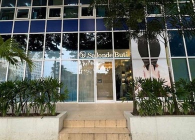 Front view of Salon de Buti in Taguig, Metro Manila, PH, showcasing its elegant modern facade and vibrant greenery.