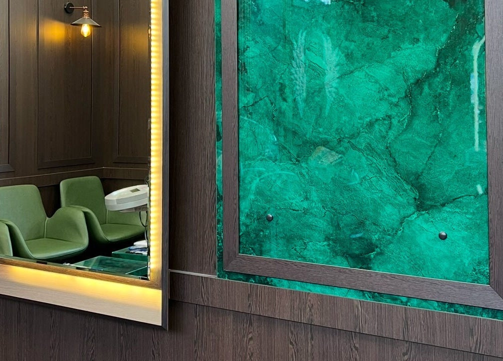 Milano Coiffeur Paradeplatz Zürich zeigt modernes Saloninterieur mit grüner Akzentwand und stilvollem Spiegel.