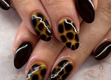 Stylish giraffe-pattern nail art at Belle Luxe Beauty in Crowthorne, England, GB. Perfect for bold fashion statements.