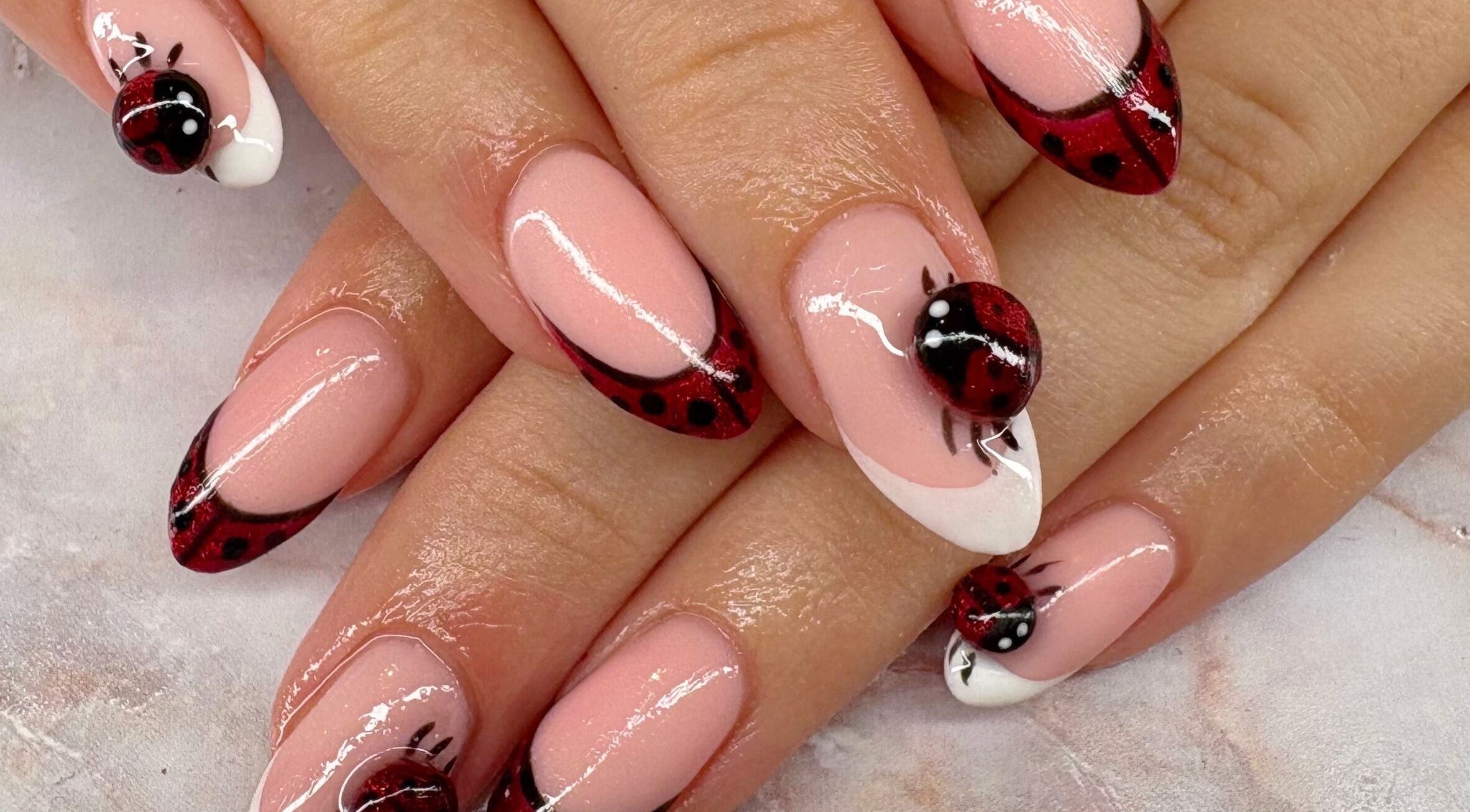 Elegant ladybug nail art at Belle Luxe Beauty in Crowthorne, England, GB showcasing intricate design.