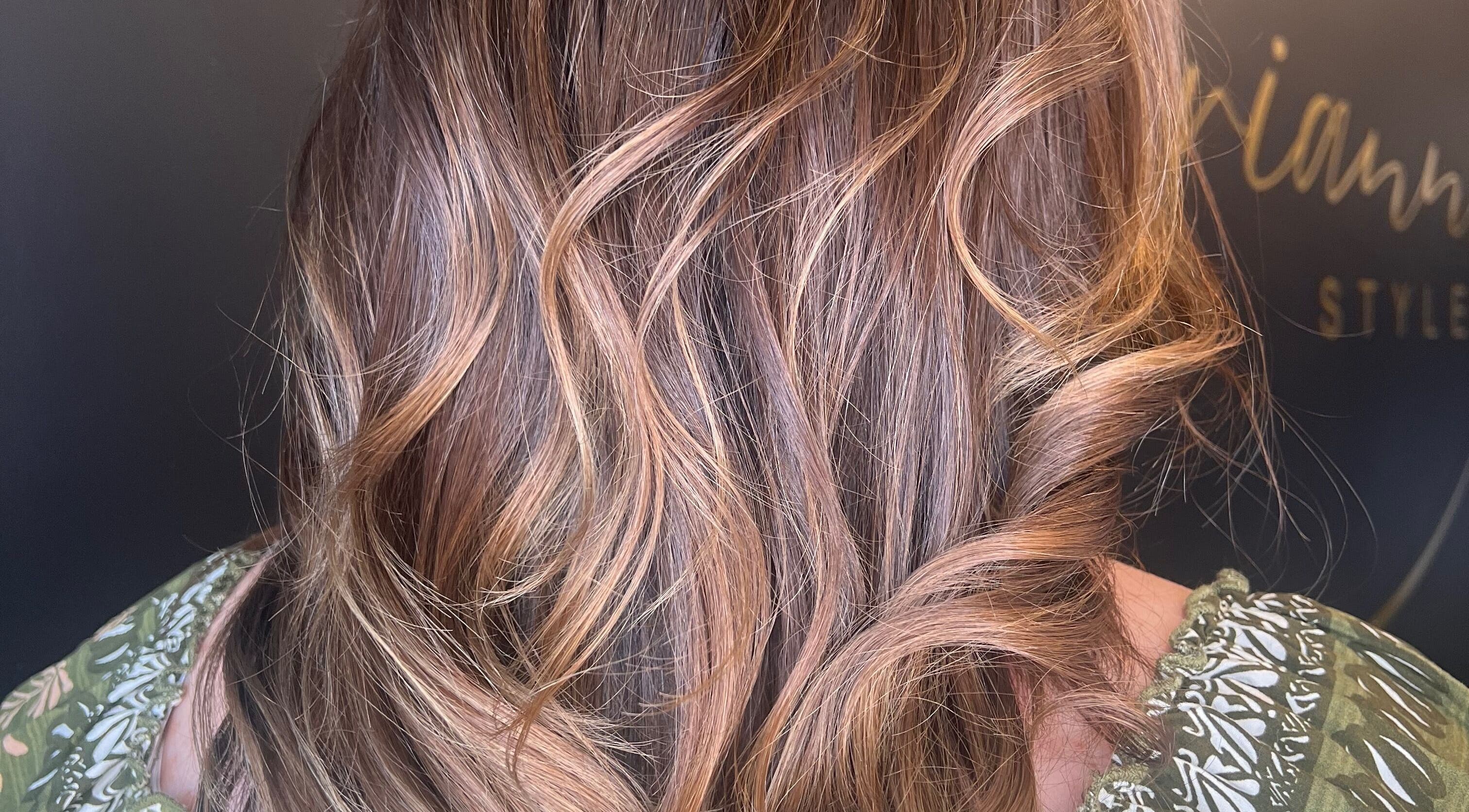 Close-up of wavy hair styled at Brianne Rae Styles in Smithtown, New York, US with rich golden highlights.