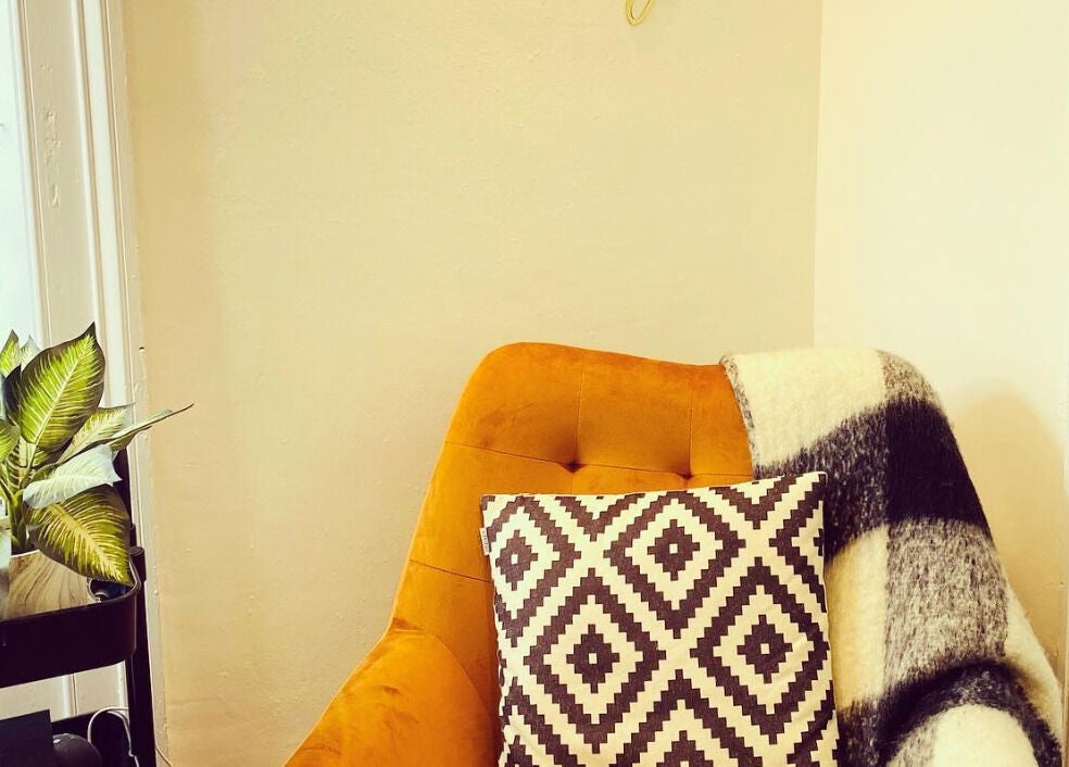 Bright cozy corner with a vibrant chair, pillow, and plant at The Lavender Lounge, Carlton In Lindrick, England, GB.