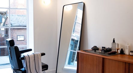 Modern barber chair and sleek workstation at Pow Slap Barbers, Knutsford, England, GB.