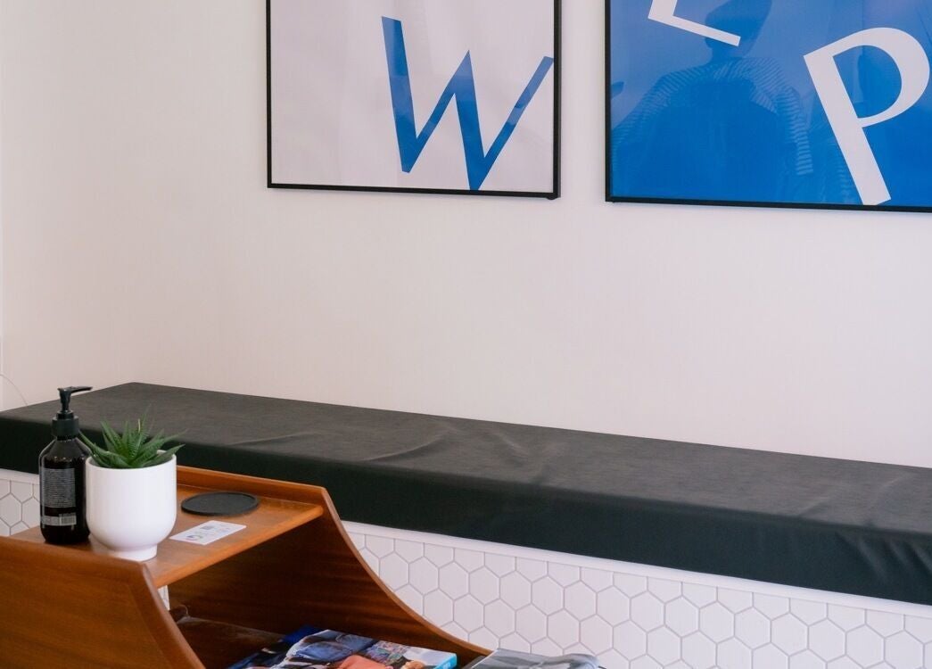 Sleek waiting area at Pow Slap Barbers, Knutsford, England with bench seating and artistic decor.