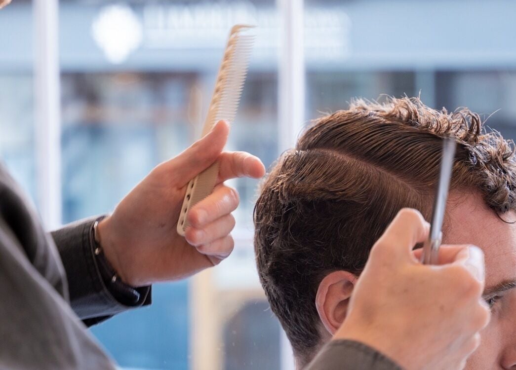Haircut in progress at Pow Slap Barbers, Knutsford, England, GB showing detailed trimming technique.