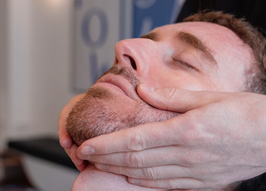 Client receiving a relaxing shave at Pow Slap Barbers, Knutsford, England, GB.