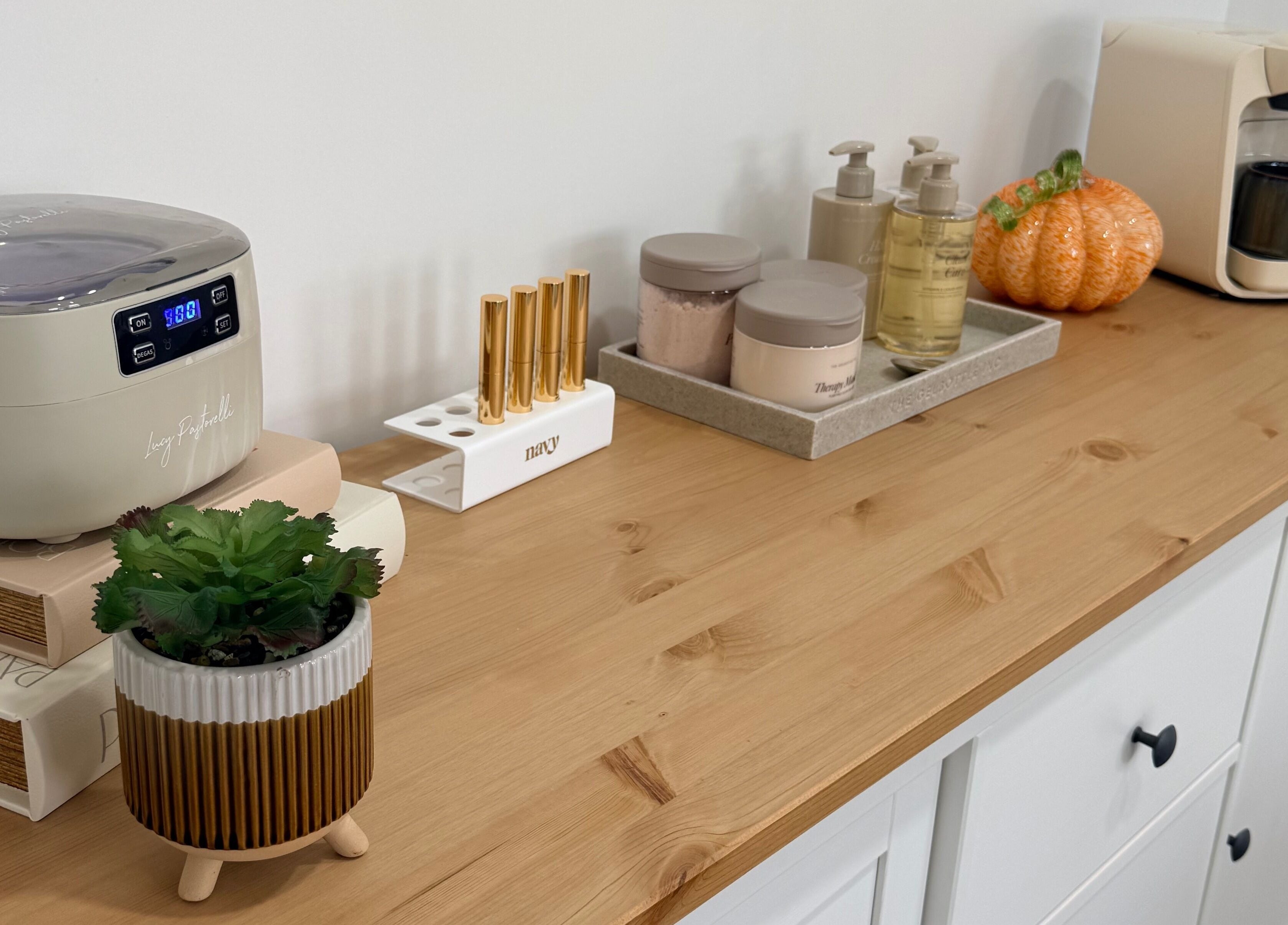 Elegant setup at Grá Nails, Strabane, Northern Ireland. Features beauty tools and products on a wooden shelf.