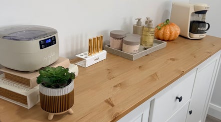 Elegant setup at Grá Nails, Strabane, Northern Ireland. Features beauty tools and products on a wooden shelf.