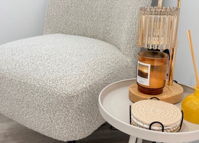 Cozy corner at Grá Nails, Strabane, Northern Ireland, GB featuring plush chair and table with aromatic candle.