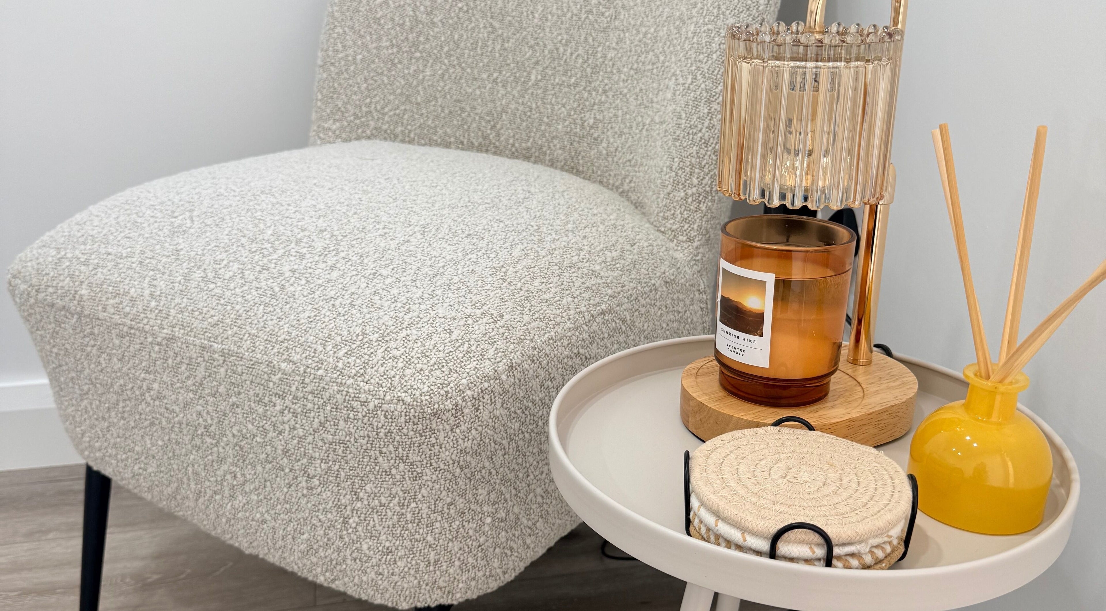 Cozy corner at Grá Nails, Strabane, Northern Ireland, GB featuring plush chair and table with aromatic candle.