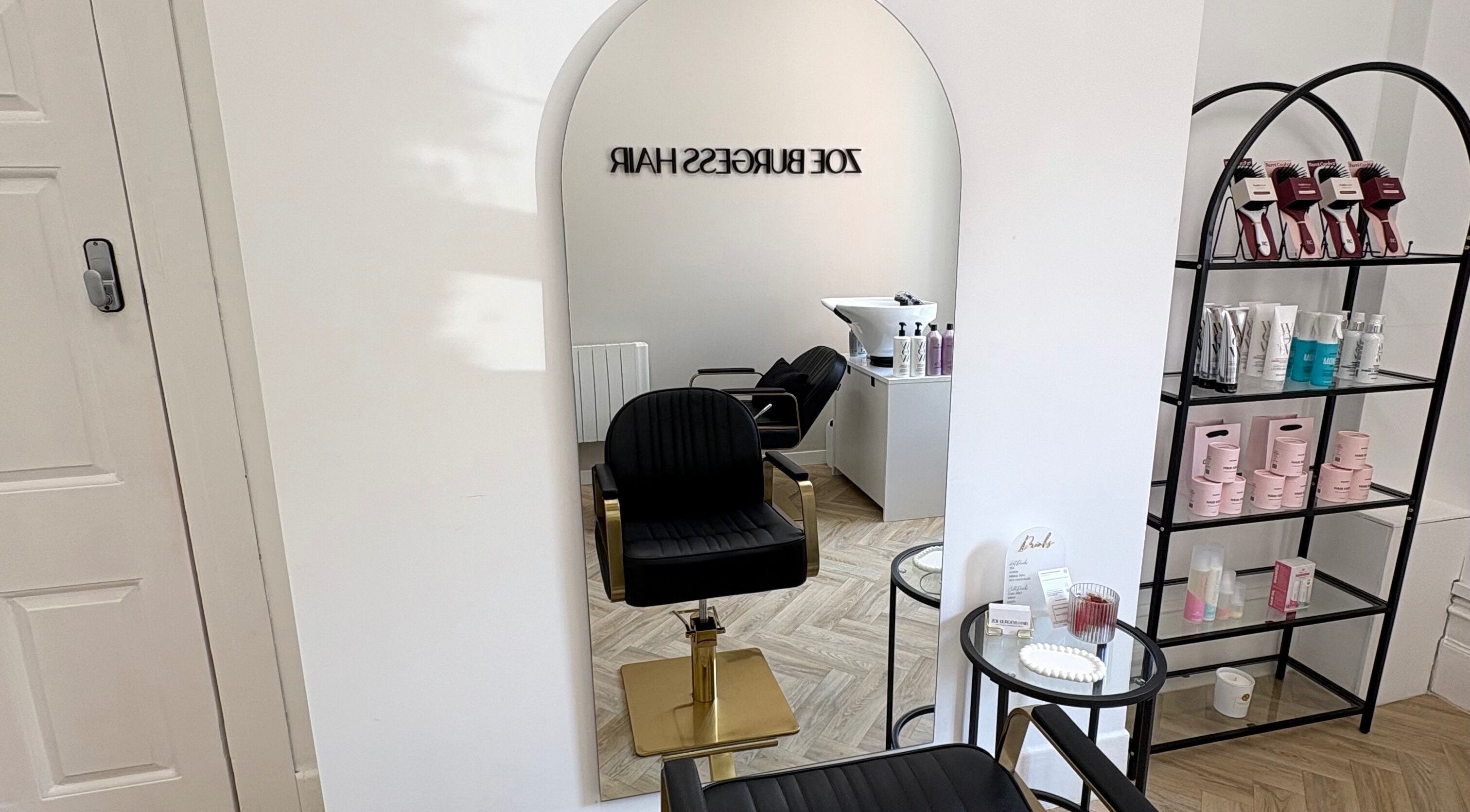 Interior of Zoe Burgess Hair salon in Banstead, England, GB featuring stylish chair and hair products.