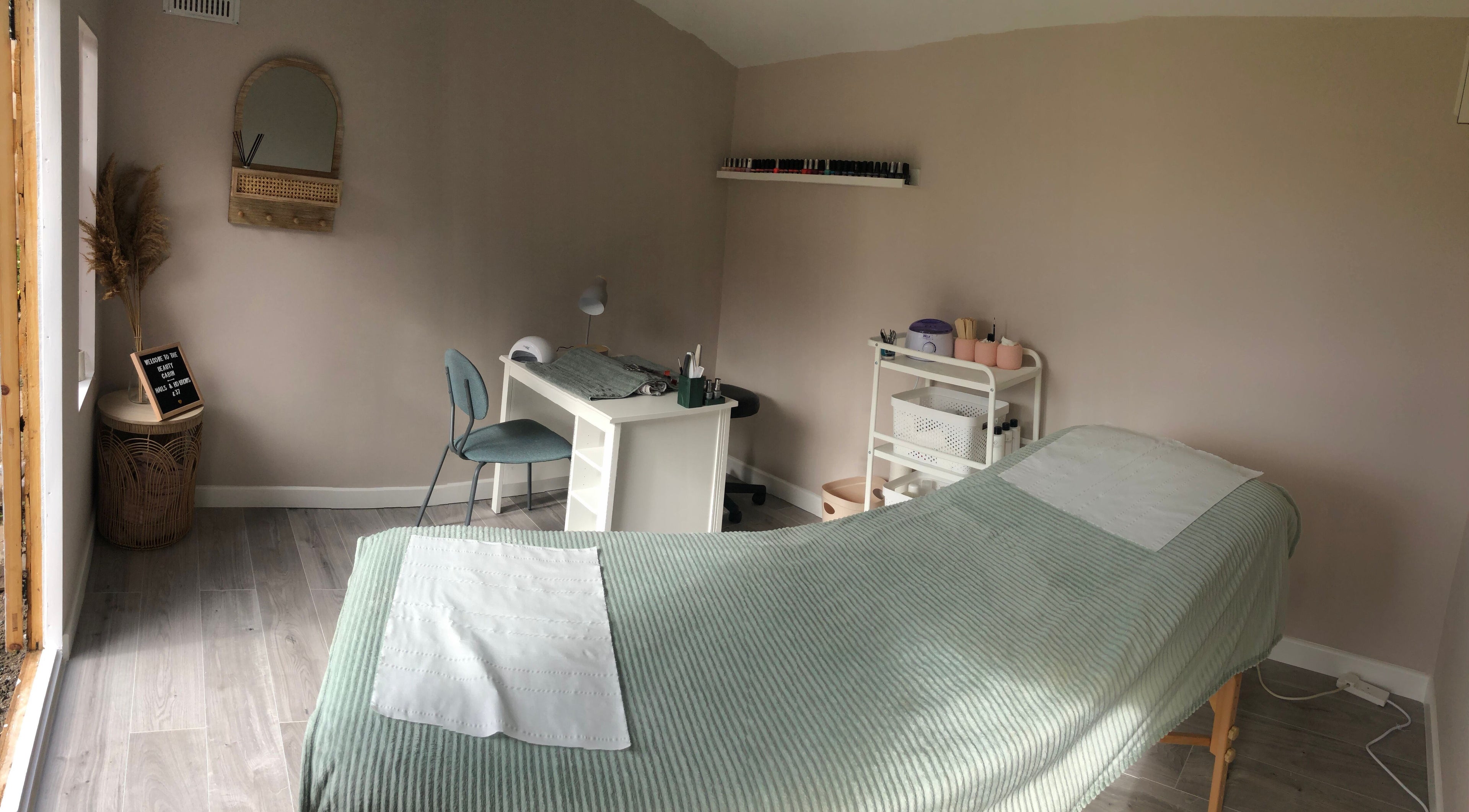 Serene treatment room at Clare Ervine Beauty, Dundonald, Northern Ireland, GB, featuring a massage bed and desk.