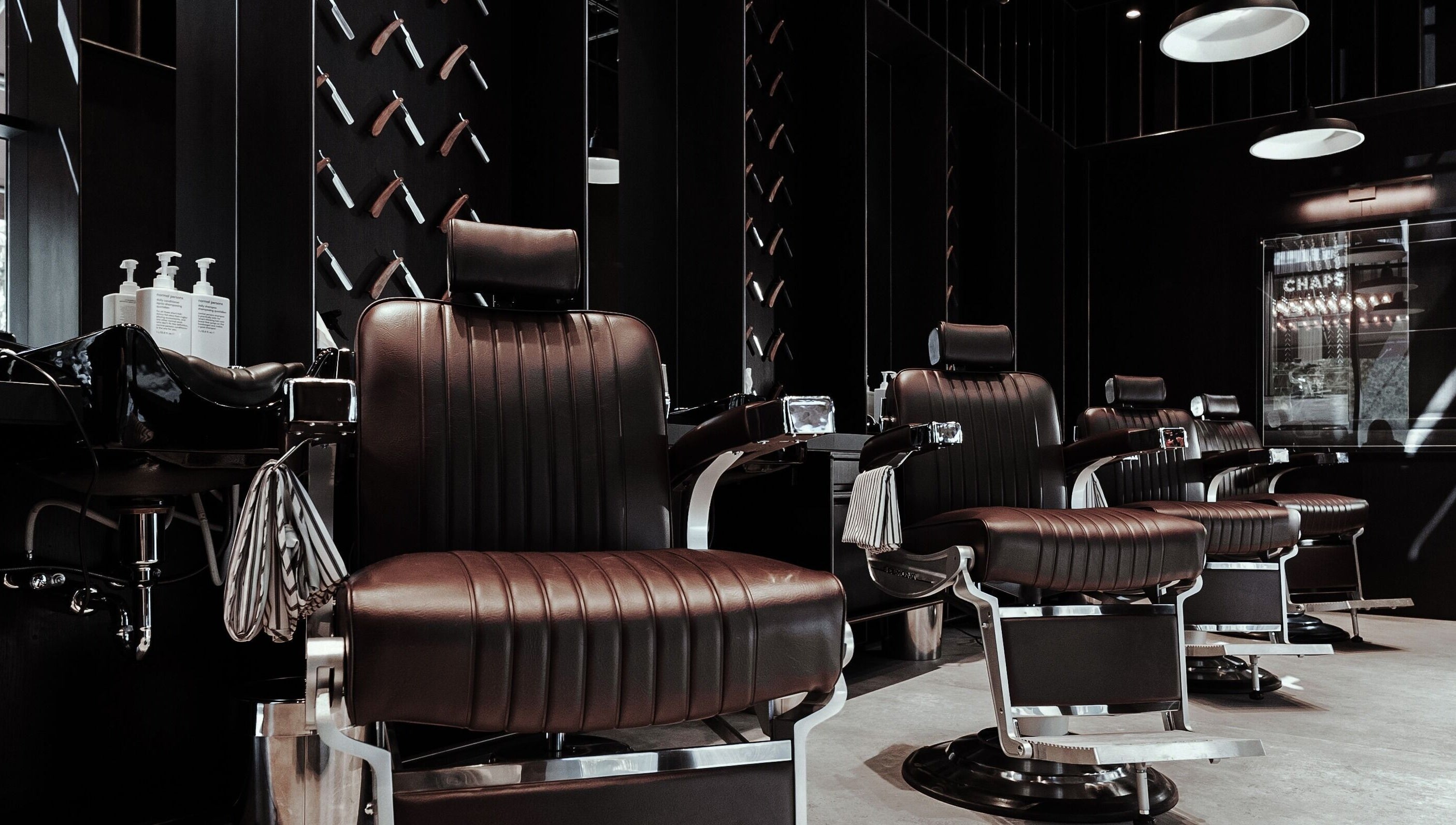Modern barber chairs at Chaps & Co - Vida Creek Beach, Dubai, Dubai, AE, offering premium grooming services.
