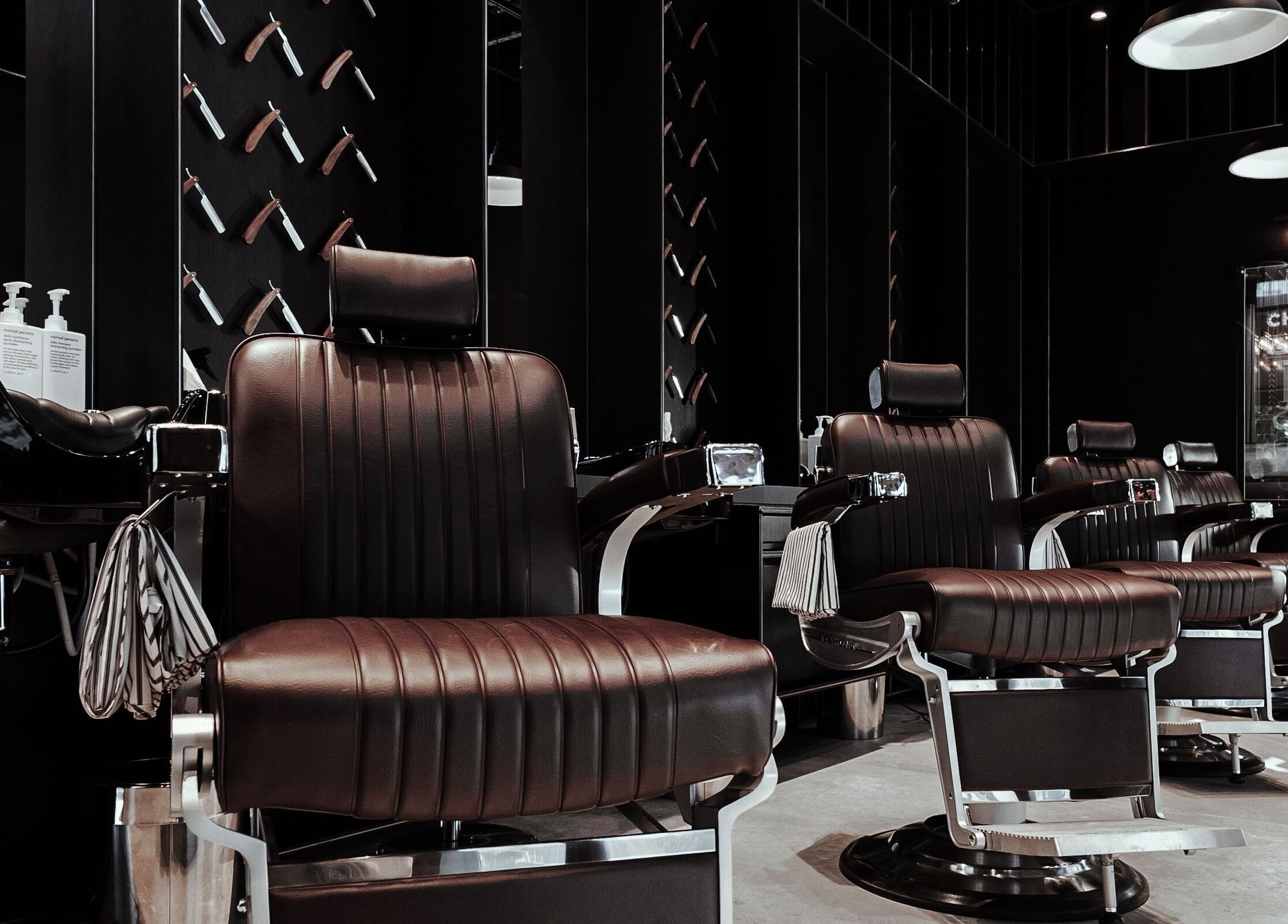 Modern barber chairs at Chaps & Co - Vida Creek Beach, Dubai, Dubai, AE, offering premium grooming services.