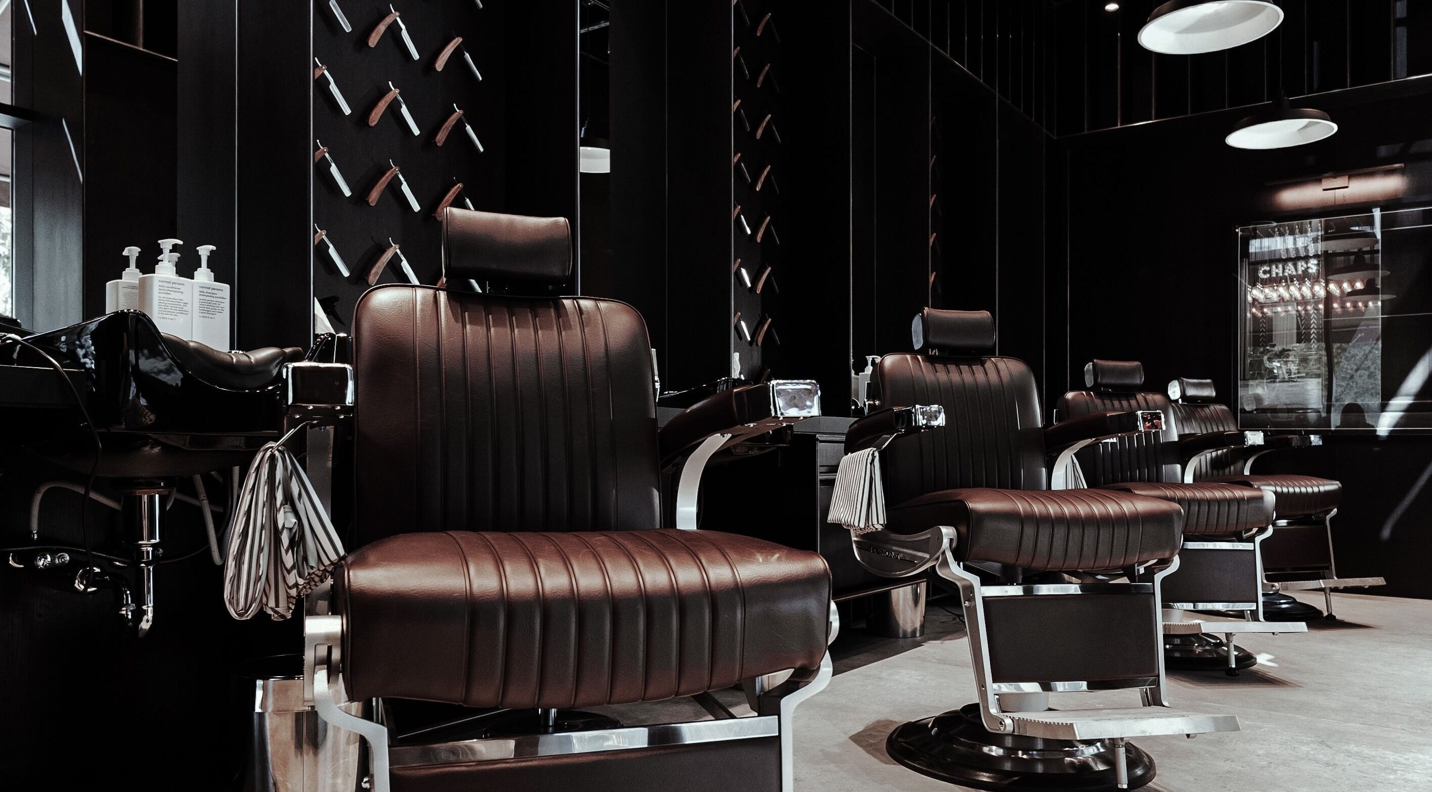 Modern barber chairs at Chaps & Co - Vida Creek Beach, Dubai, Dubai, AE, offering premium grooming services.