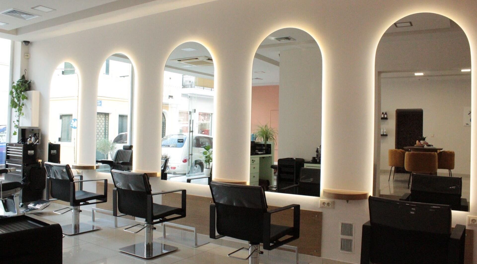 Μοντέρνος εσωτερικός χώρος κομμωτηρίου Hairloom στη Ζάκυνθο, GR με καμάρες και φινετσάτα καθίσματα.