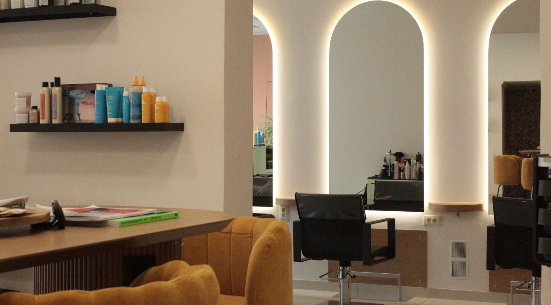 Σύγχρονο εσωτερικό του χώρου Hairloom στη Ζάκυνθο, GR με κομψές καρέκλες και προϊόντα ομορφιάς.