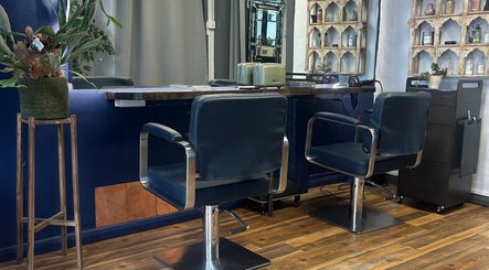 Modern salon interior at Venetia Hair, Hitchin, England, GB showcasing sleek styling chairs and decor.