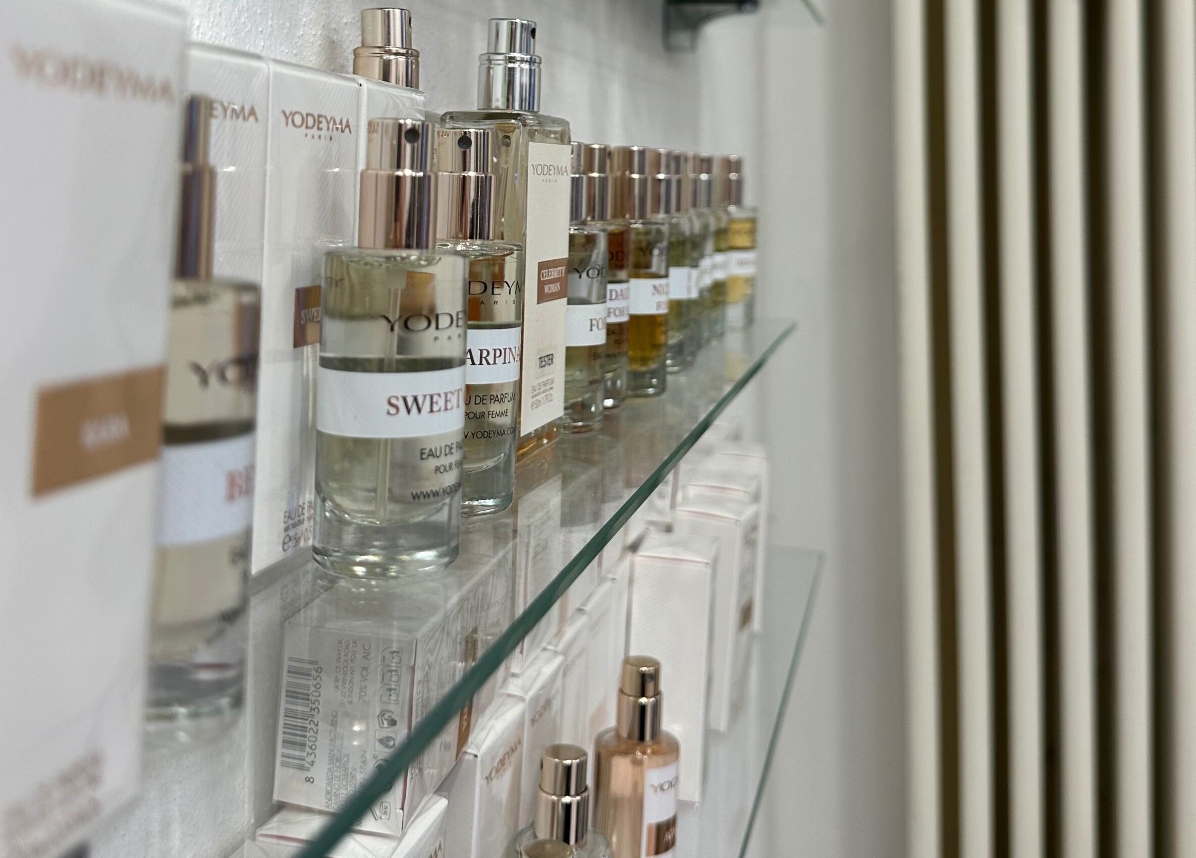 Collezione di profumi da Mani di Forbice, Ferrara, Emilia-romagna, IT su una mensola trasparente.