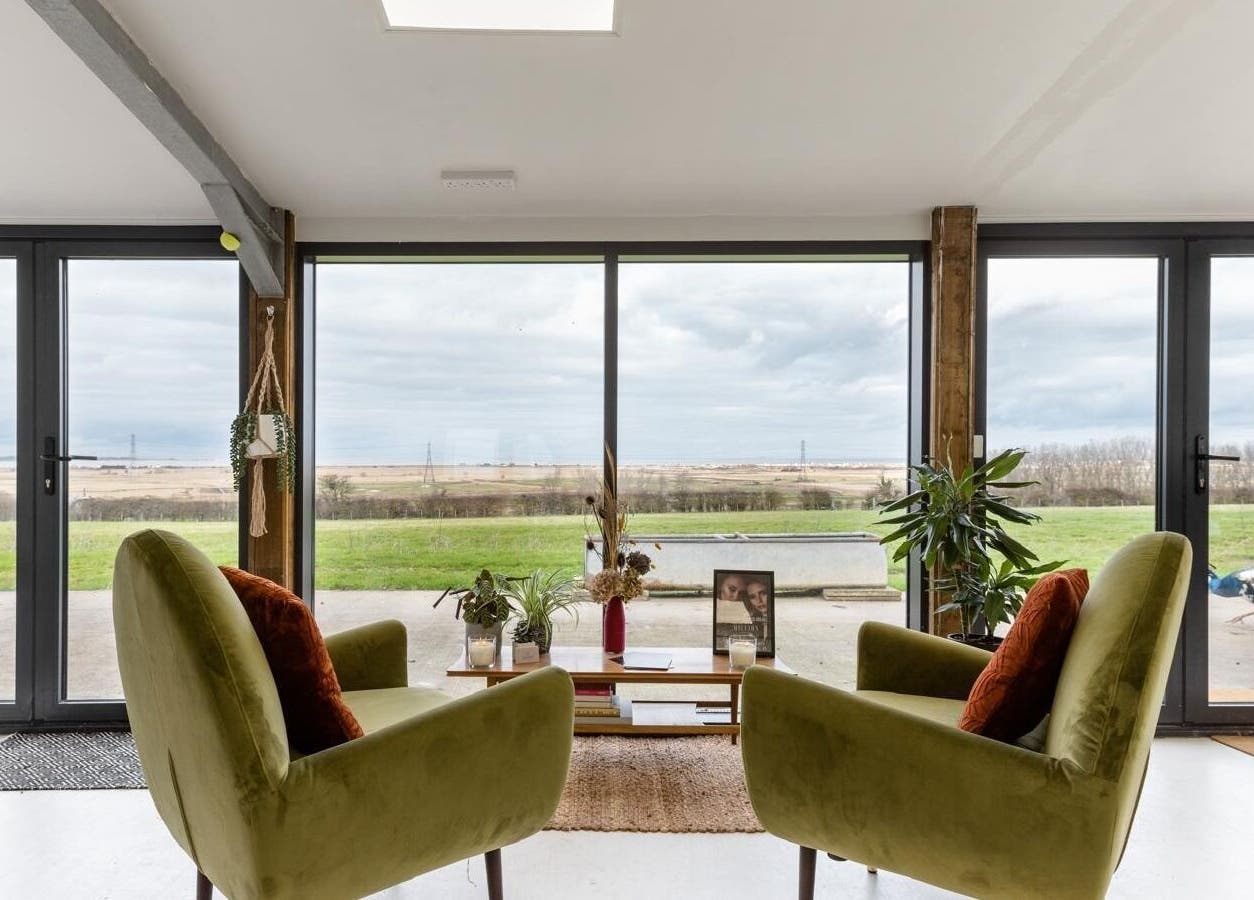 Cozy lounge at Joshua Rose Hair- Creative Space Kent in Faversham, England with panoramic countryside view.