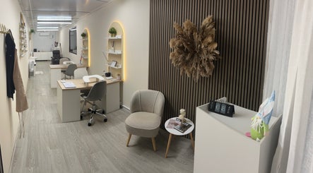 Chic interior of Luxe Enhancements in Rochester, England, GB with stylish workstations and plush seating.