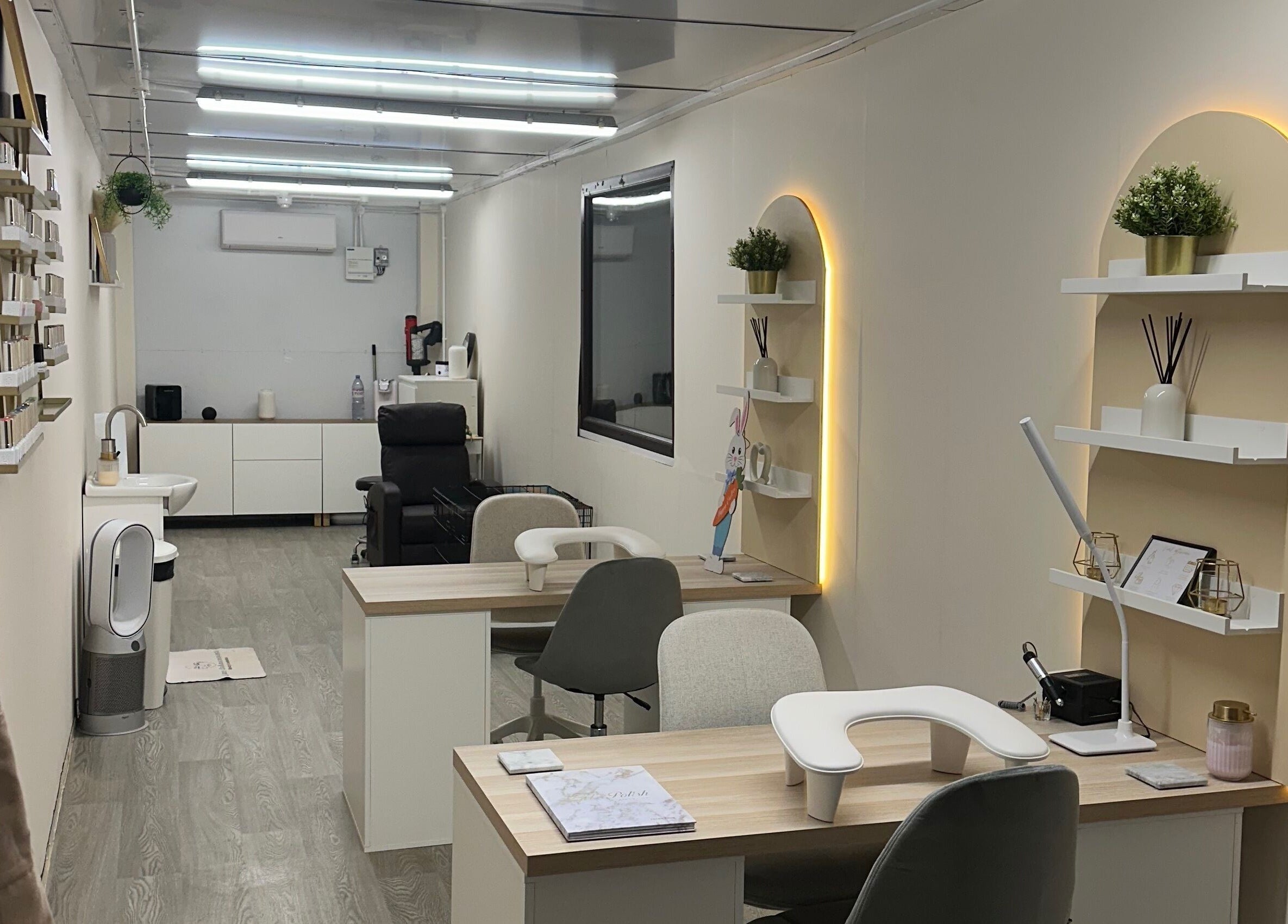 Modern nail salon interior at Luxe Enhancements in Rochester, England, GB, featuring sleek workstations and cozy decor.