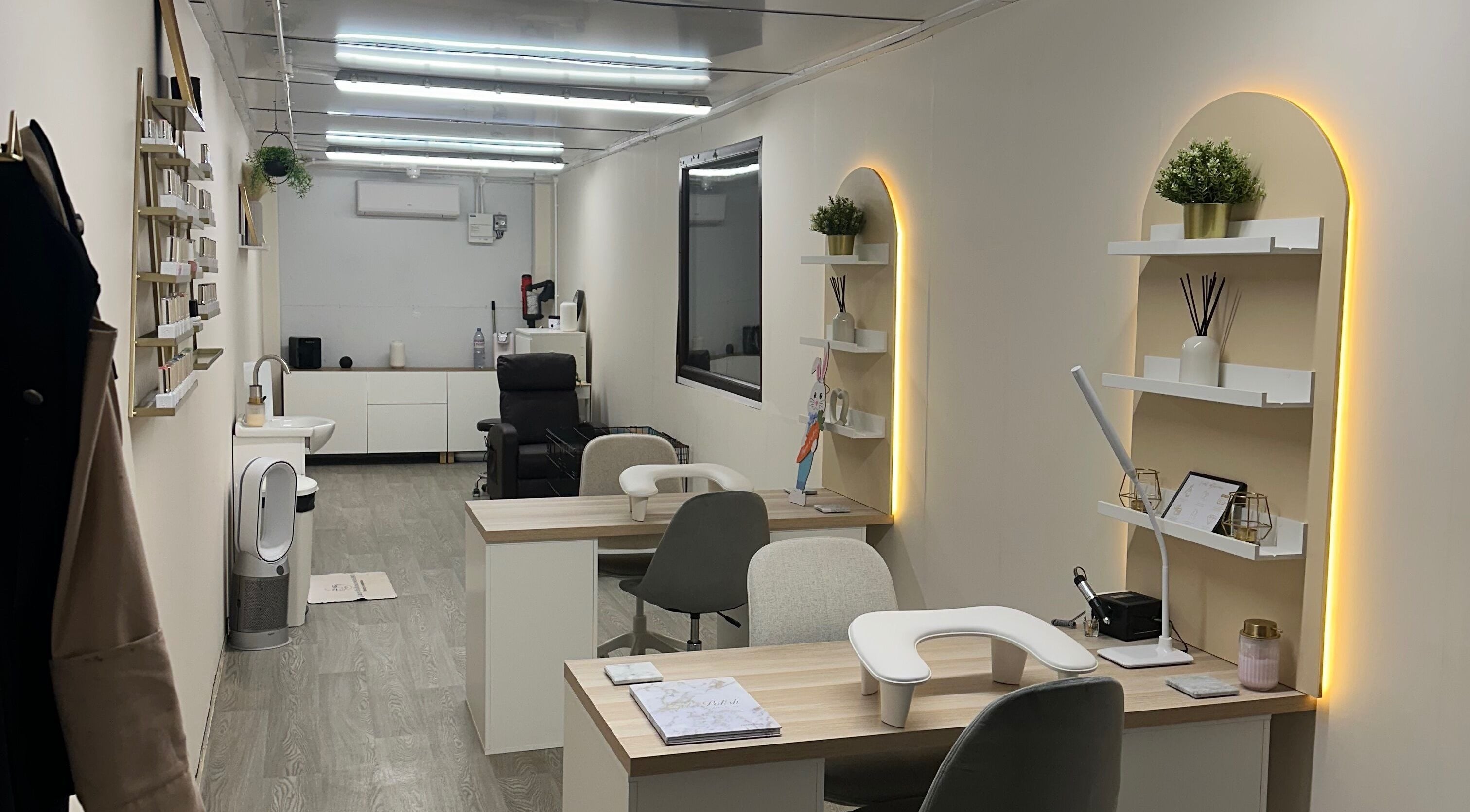 Modern nail salon interior at Luxe Enhancements in Rochester, England, GB, featuring sleek workstations and cozy decor.