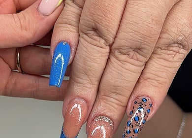 Elegant acrylic nails with blue and nude designs at Glitz&GlamNailBar, Winsford, England, GB.