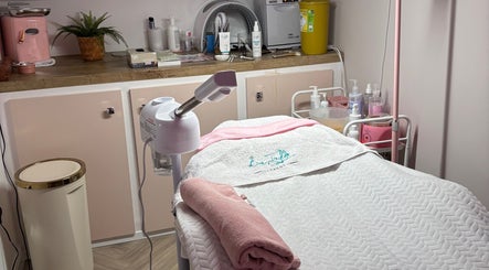 Relaxing treatment room at Aglow by VL, Essington, England, GB, featuring a massage table and skincare products.