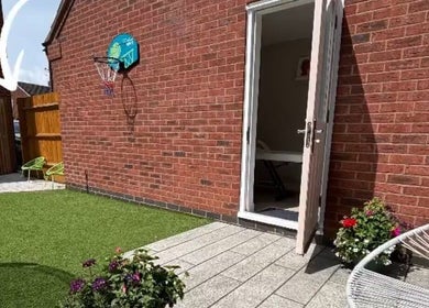 Outdoor seating and open door at Aglow by VL, Essington, England, GB, showcasing a tranquil garden space.