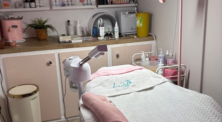 Spa treatment room at Aglow by VL, Essington, England, GB with bed and skincare products.