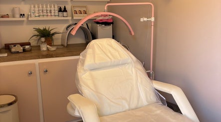Serene treatment room at Aglow by VL in Essington, England, GB, featuring a modern chair and skincare essentials.