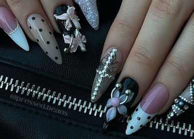 Intricate nail art at Pressed Beans, Montréal, Québec, CA. Features black, pink, and white designs with embellishments.
