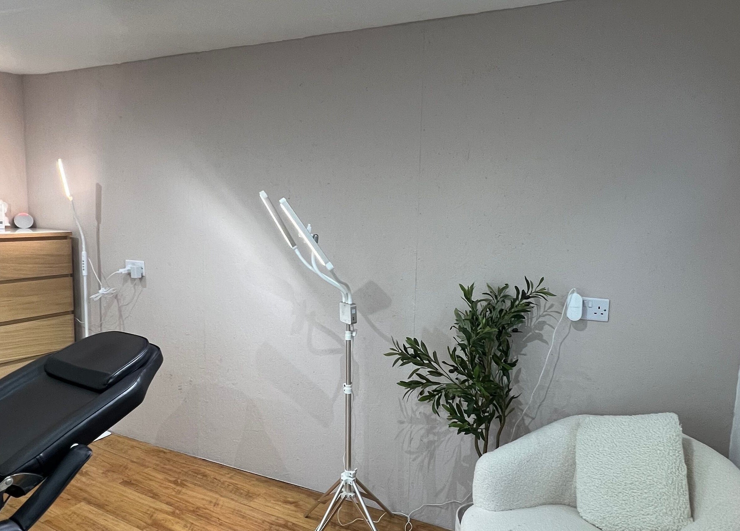 Relaxing treatment area at At Tiffany’s Brows and Beauty, Northam, England, GB, featuring a modern chair and lush plant.