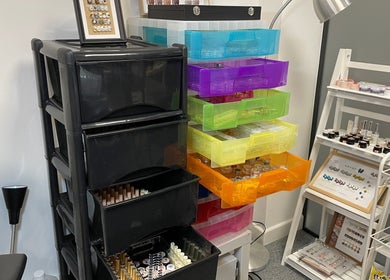 Organized nail supply racks at Pineapple Chuncks Nail, Manchester, England, GB showcasing tools and accessories.