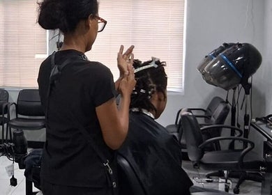 A stylist working on a client's hair at Jaycee's Beauty Empire in Petit Valley, Diego Martin Regional Corporation, TT.