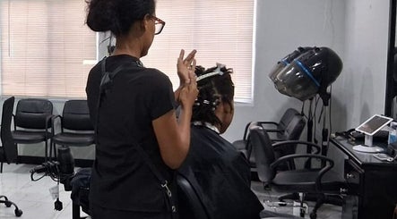 A stylist working on a client's hair at Jaycee's Beauty Empire in Petit Valley, Diego Martin Regional Corporation, TT.