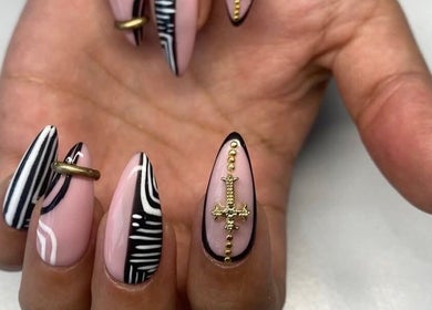Intricate nail art at Maria's Studio in Gqeberha, Eastern Cape, ZA showcasing black and gold designs.