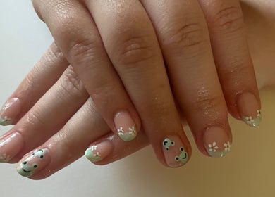 Delicate floral nail art at Ruth Elizabeth Beauty in Hinckley, England, GB, on a woman's manicured hands.