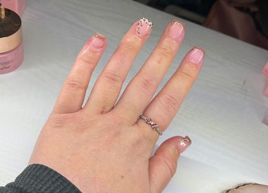 Elegant nail art at Ruth Elizabeth Beauty, Hinckley, England, GB showcasing nude and gold French manicure.