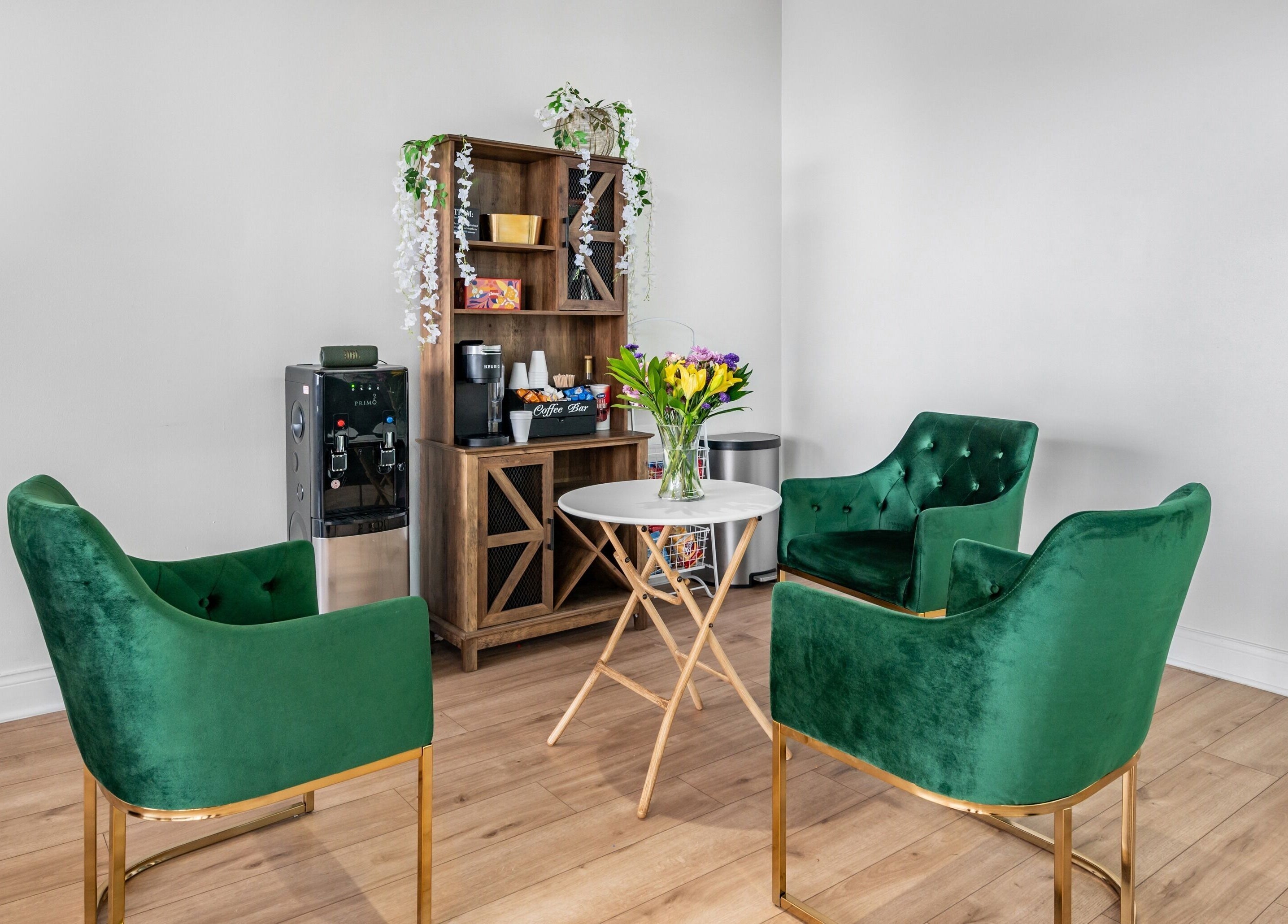 Stylish green velvet chairs in Artisan Theory Salon, Villa Park, Illinois, US create an inviting conversation nook.