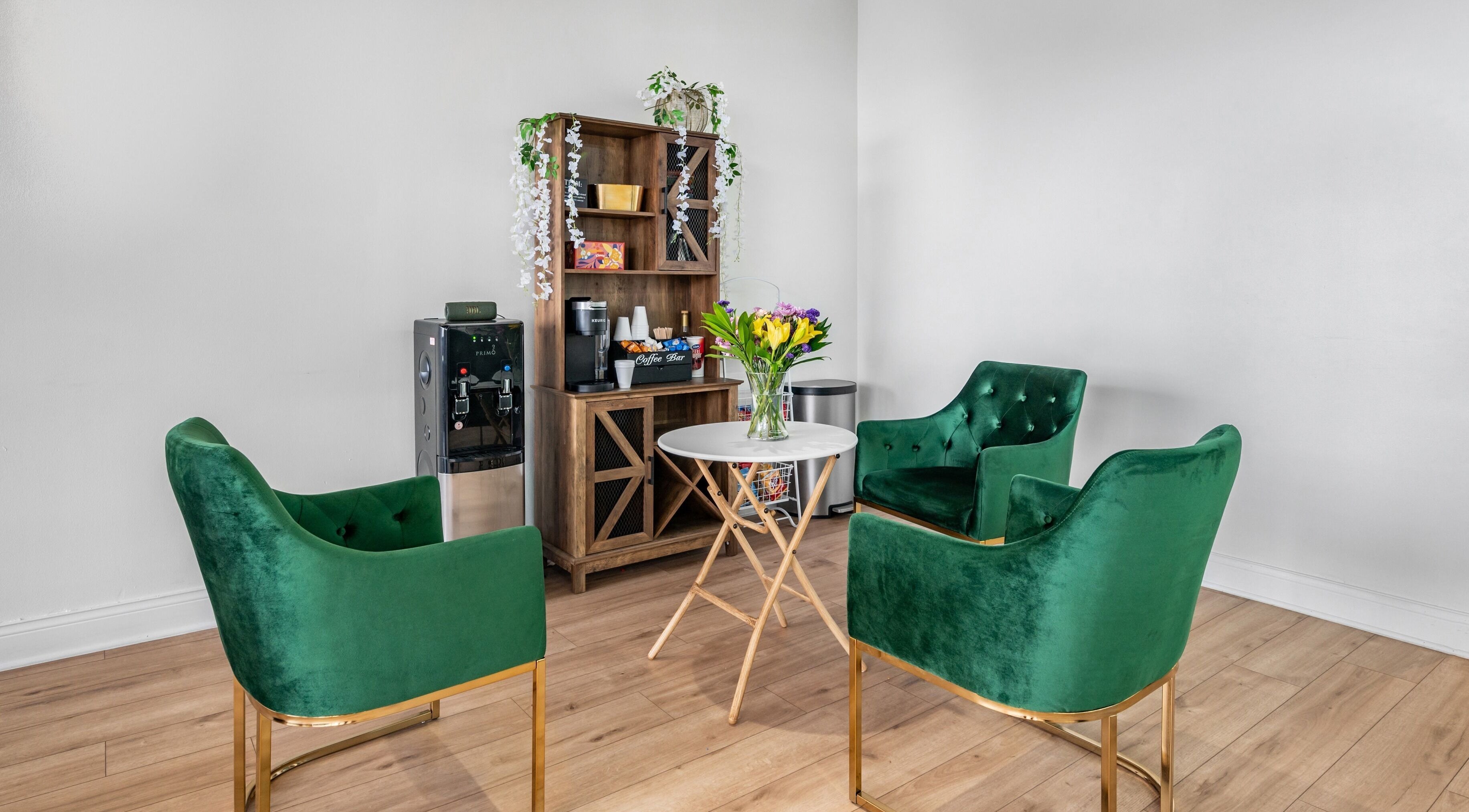 Stylish green velvet chairs in Artisan Theory Salon, Villa Park, Illinois, US create an inviting conversation nook.