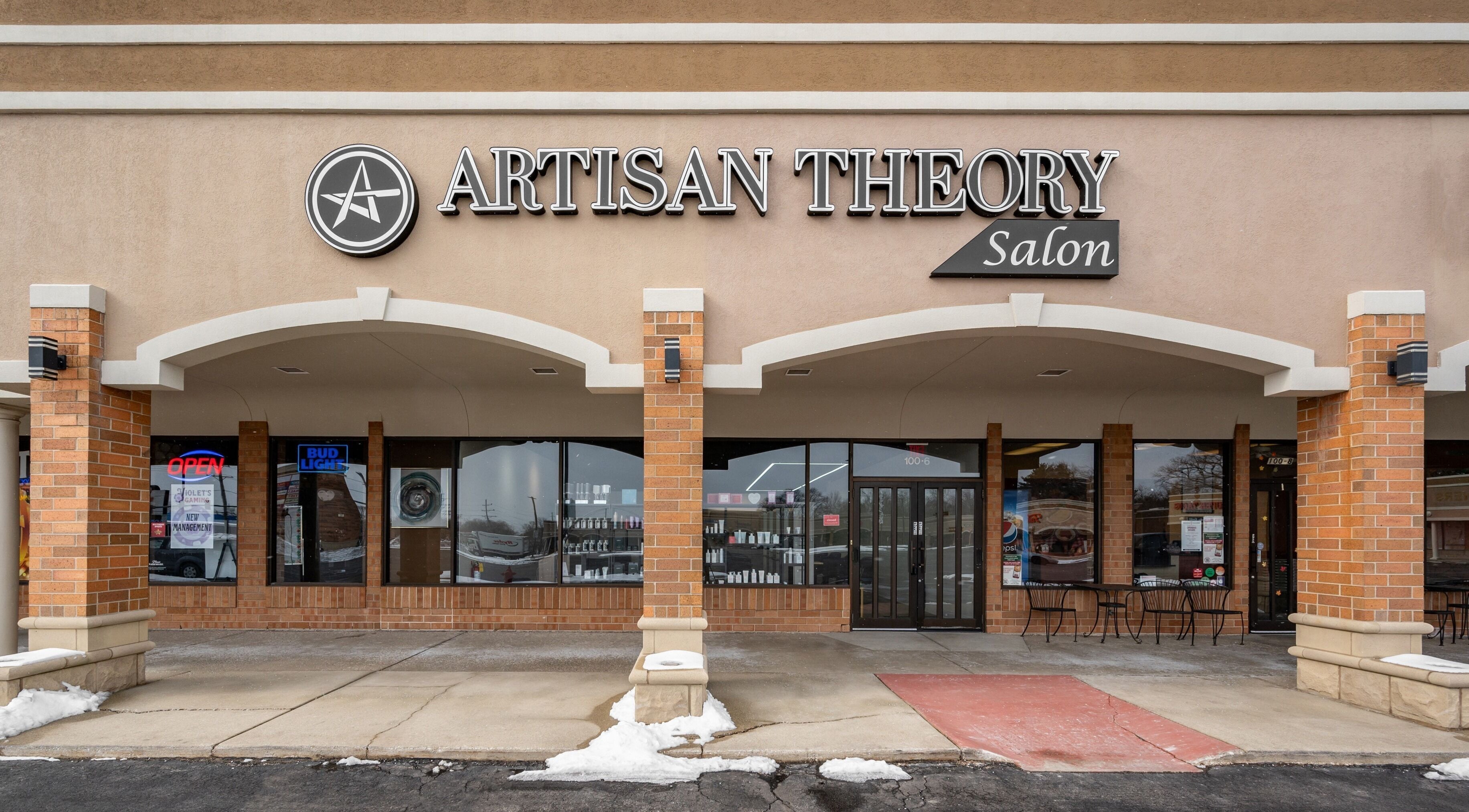 Artisan Theory Salon entrance in Villa Park, Illinois, US, showcasing its modern storefront and logo.