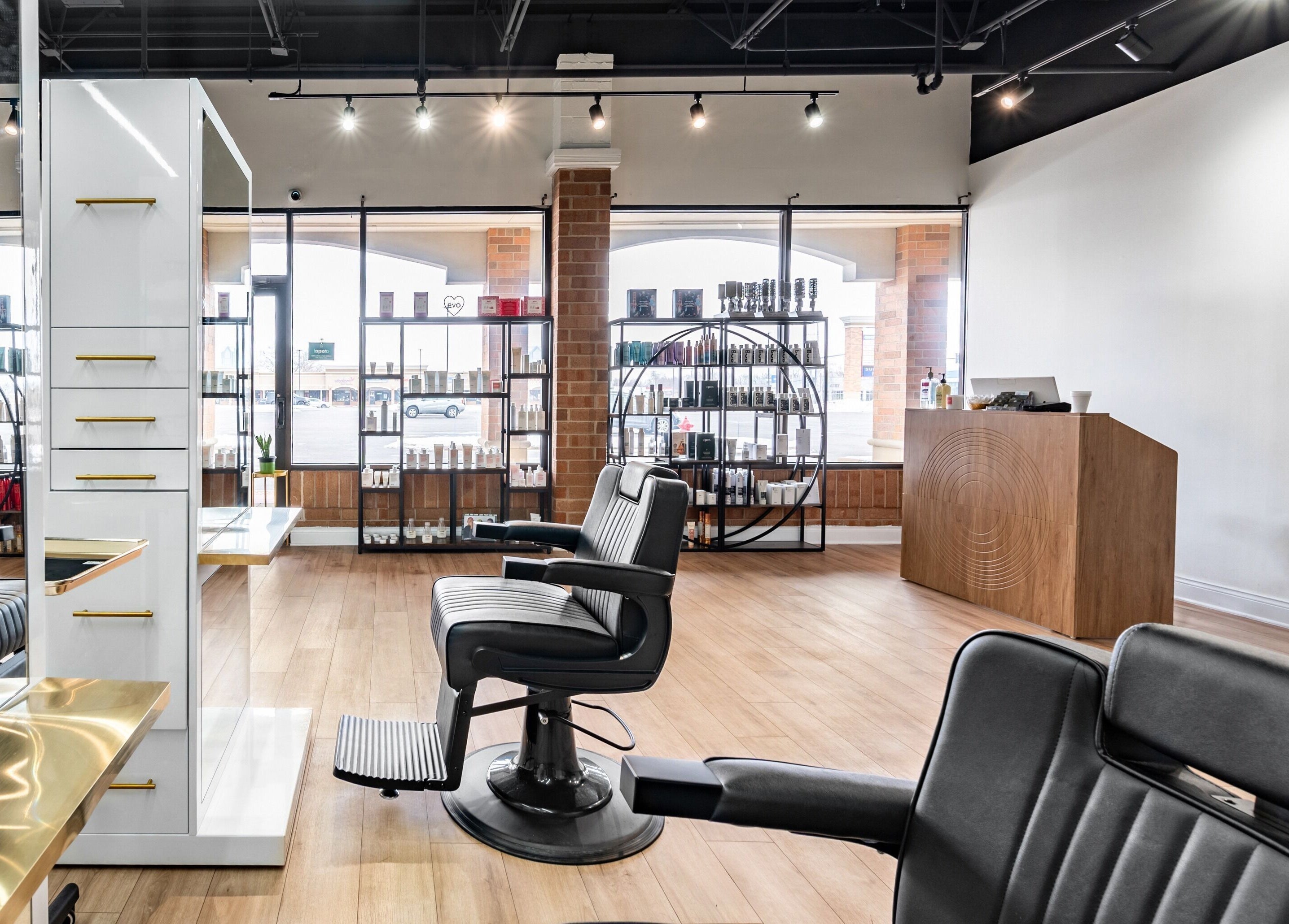 Modern interior of Artisan Theory Salon in Villa Park, Illinois, US, featuring stylish chairs and display shelves.
