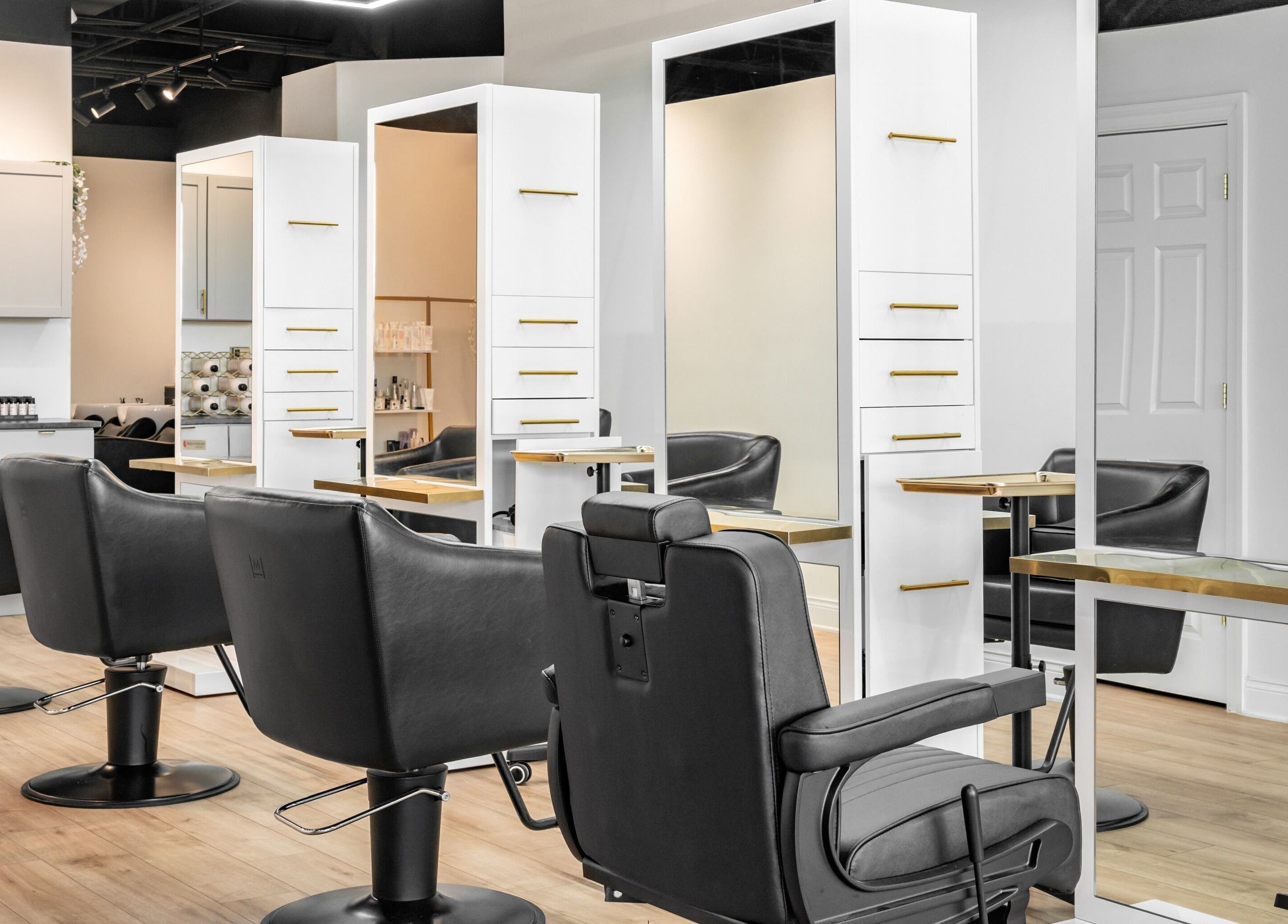 Stylish interior of Artisan Theory Salon in Villa Park, Illinois, US showcasing sleek black chairs and modern design.